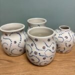 La Pause Argile : petits pots fleuris en pointillés bleu marine et rouge